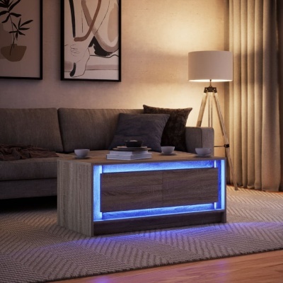 Mesa de centro em madeira clara com iluminação LED azul, sofá cinzento, almofadas, tapete bege e luminária de piso com base tripé