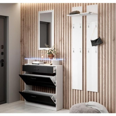 Móvel de entrada com sapateira preta e branca, espelho e painéis brancos com ganchos