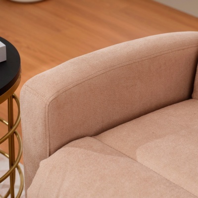 Sofá bege claro em tecido com mesa lateral metálica dourada e tampo preto