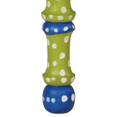 Detalhe de objeto em madeira pintada verde e azul com bolinhas brancas