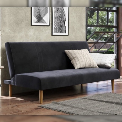 Sofá cinzento escuro com almofadas numa sala com parede cinzenta e chão de madeira