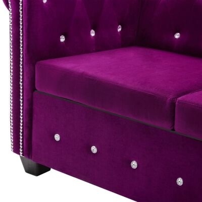 Sofá roxo de veludo com botões decorativos e tachas prateadas