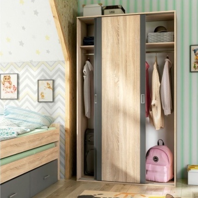 Roupeiro de madeira clara com portas de correr e roupa no interior num quarto decorado