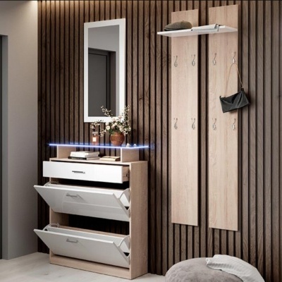 Móvel de entrada com gavetas brancas abertas, espelho branco e painéis de madeira com ganchos para pendurar, montado numa parede de ripas de madeira.