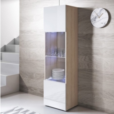 Móvel alto de madeira clara com portas brancas e secção central em vidro, com pratos e copos expostos