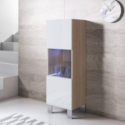 Móvel alto com porta de vidro e copos visíveis, em interior minimalista com parede de madeira clara e escadas