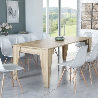 Mesa de jantar em madeira clara com oito cadeiras brancas e ambiente interior com janelas e quadros