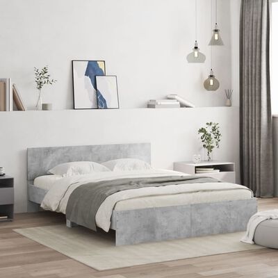 Cama de casal cinzenta com roupa de cama branca e cinzenta em quarto minimalista com mesas de cabeceira e candeeiros suspensos
