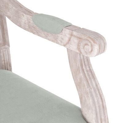 Braço e assento de cadeira em madeira clara com estofos verdes