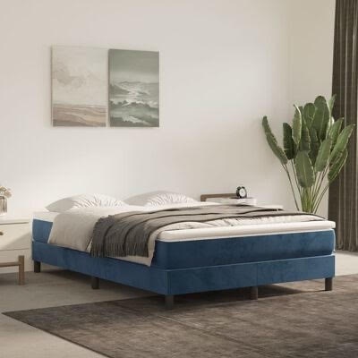 Cama de casal com estrutura azul, roupa de cama cinza e branca, planta alta e quadro na parede