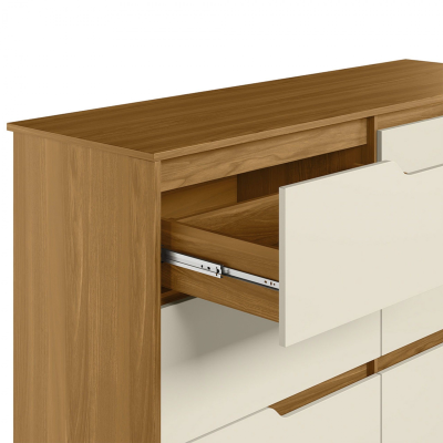 Móvel de madeira castanho claro com gavetas brancas, uma gaveta aberta