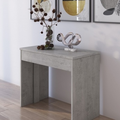 Mesa cinzenta estilo cimento com decoração e quadros geométricos atrás
