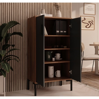 Armário de madeira com portas pretas aberto em sala com planta e mesa ao fundo