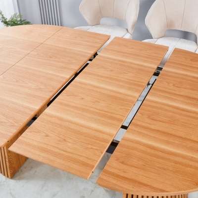 Mesa de madeira clara e cadeiras estofadas bege em ambiente interior