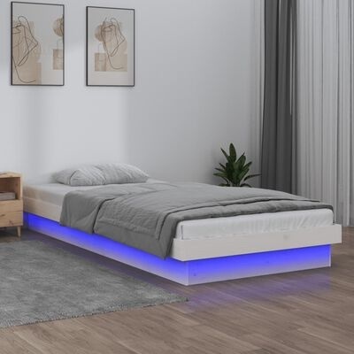 Cama de solteiro branca com luz LED azul e roupa de cama cinzenta num quarto moderno