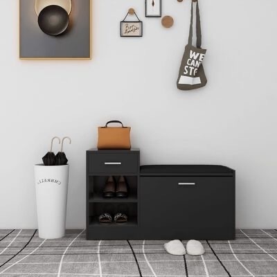 Móvel de entrada preto com banco acolchoado, sapatos, guarda-chuvas em porta branco, saco de pano cinza pendurado e decoração de parede branca