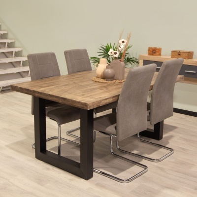 Mesa de jantar em madeira com quatro cadeiras cinza e decoração no centro, em ambiente interior.