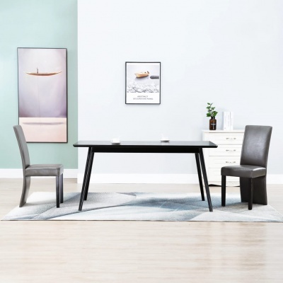 Conjunto de mesa preta e duas cadeiras castanhas num ambiente minimalista com quadros de barco na parede e tapete cinzento.