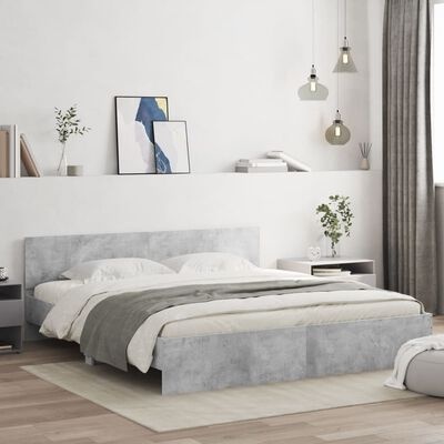 Quarto com cama de casal cinzenta, roupa de cama branca e cinza, mesas de cabeceira, candeeiros pendentes e decoração minimalista