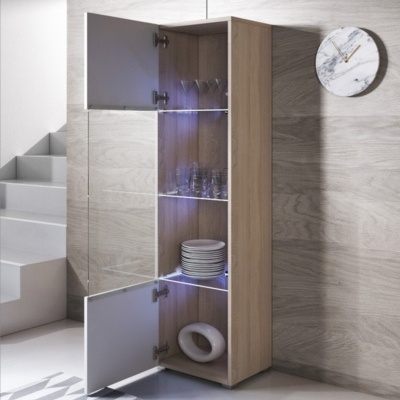 Armário alto de madeira clara com portas cinza aberto mostrando copos, pratos e objeto decorativo com iluminação azul
