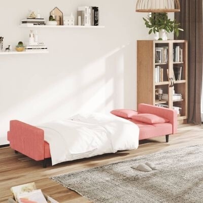 Sofá-cama rosa moderno estendido em sala com tapete cinza e estante de madeira