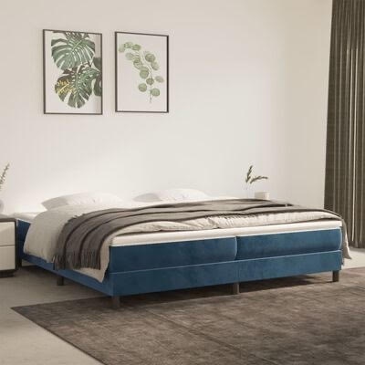 Cama estofada azul com roupa de cama cinza e decoração minimalista