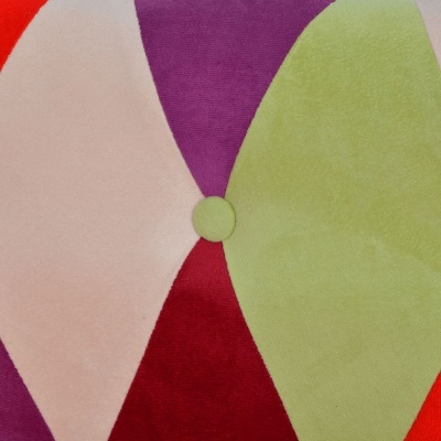 Tecido estofado colorido com padrão geométrico e botão forrado