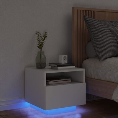 Mesa-de-cabeceira branca minimalista com luz azul LED na base ao lado de cama de madeira