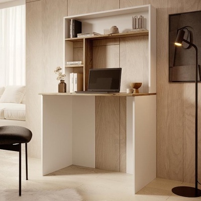 Secretária branca com tampo de madeira clara e estantes superiores em ambiente com parede de madeira e janela com cortina branca