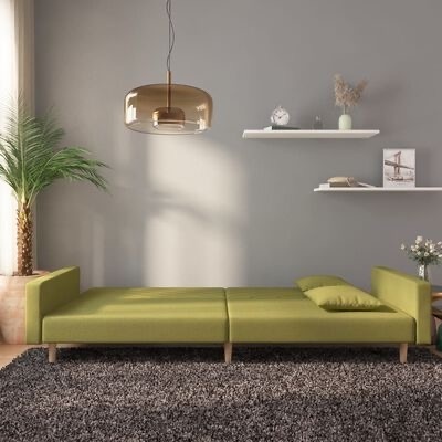 Sofá verde claro moderno sobre tapete cinza em sala com paredes cinzentas e prateleiras brancas