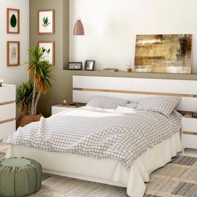 Quarto mobilado com cama branca, roupa de cama quadriculada, mesas de cabeceira, cómodas, pufe verde e quadros decorativos.