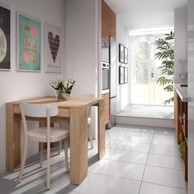 Mesa de jantar de madeira clara com cadeiras brancas em cozinha moderna com armários de madeira e azulejos cinzentos