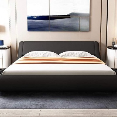 Cama de casal preta estofada com colcha branca e manta laranja