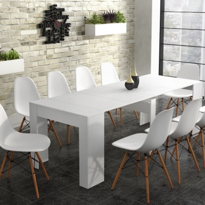 Mesa de jantar branca com cadeiras brancas e parede de tijolos claros com plantas