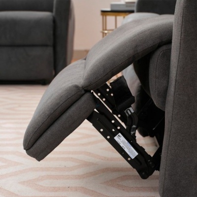 Poltrona reclinável cinzenta com estrutura metálica visível, numa sala com carpete bege.