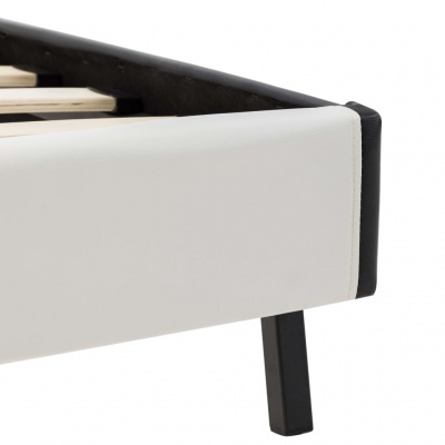 Canto de base de cama branca com perna preta e ripas de madeira visíveis