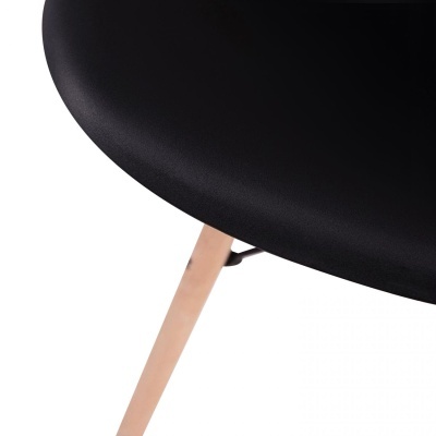 Canto de assento de cadeira preto com perna de madeira clara sobre fundo branco