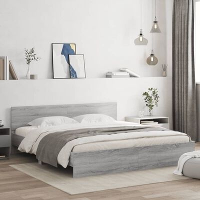 Cama de casal cinza clara com roupa de cama branca e cinza, candeeiros pendentes e decoração minimalista.