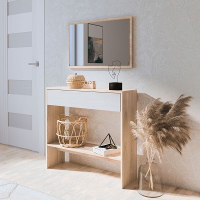 Consola de madeira clara com gaveta branca, espelho e elementos decorativos numa parede branca com padrão floral