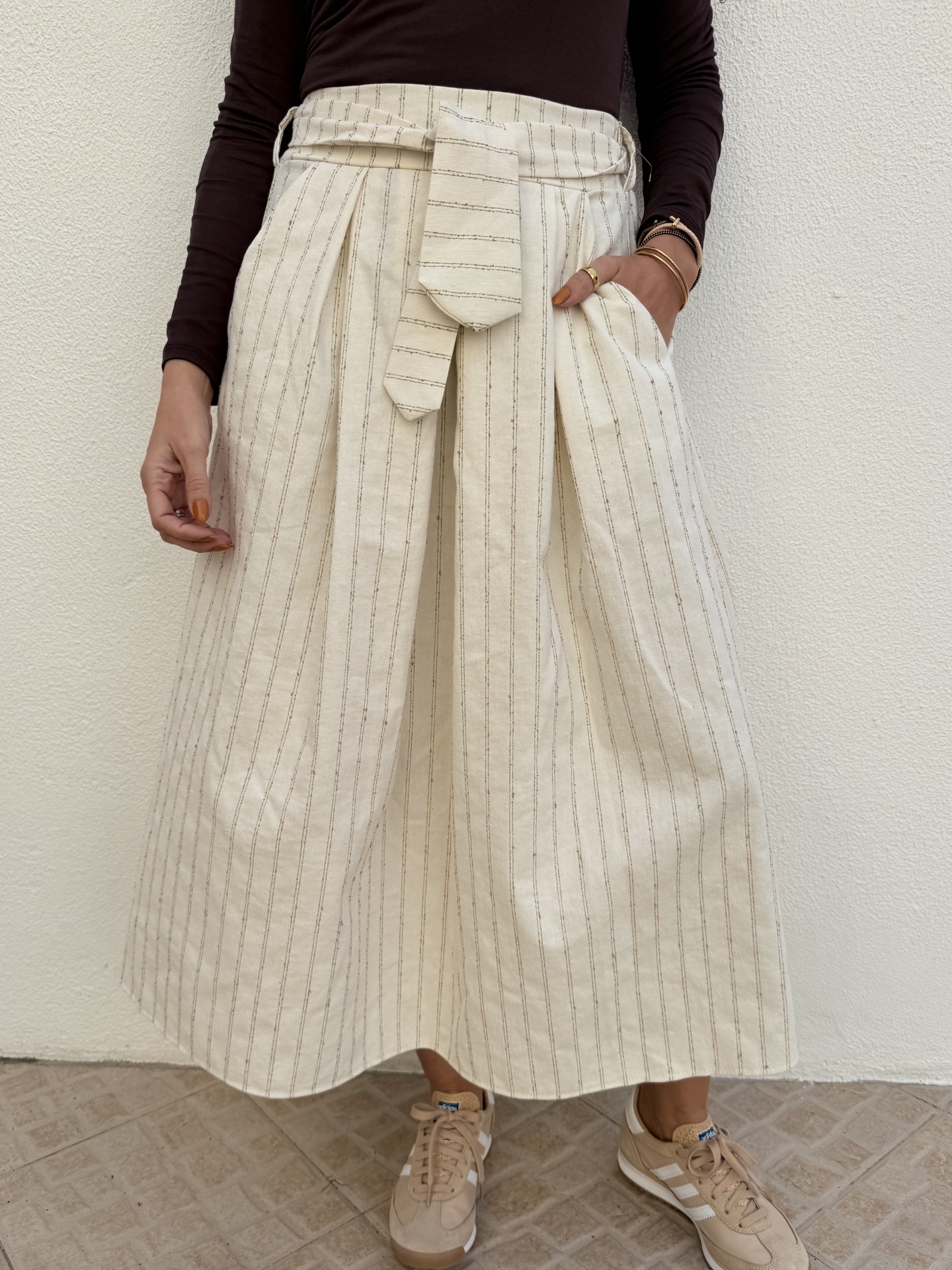 Saia midi bege claro riscada com faixa cintura e ténis bege
