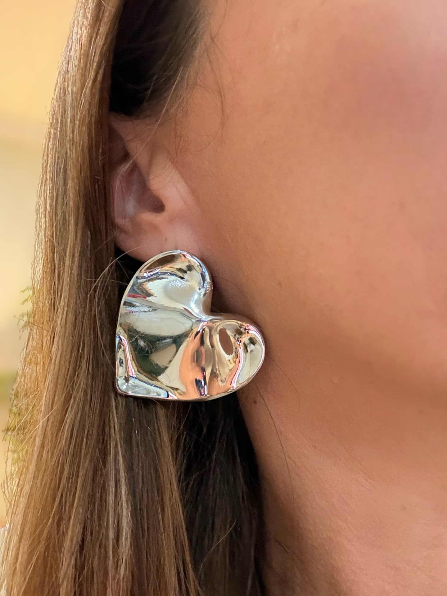 Brinco prateado em forma de coração ondulado