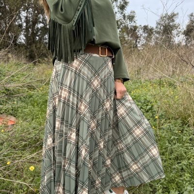 saia plissada xadrez verde bege castanho, camisola verde com franjas, cinto castanho, sapatilhas brancas riscas verdes em campo