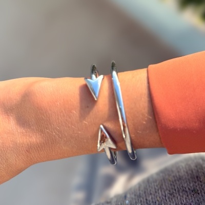 Pulseira em metal prateado com pontas triangulares no pulso