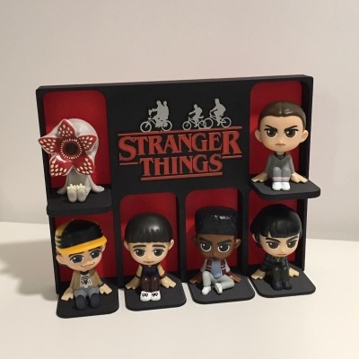 Mini figuras oficiais da série Stranger Things com suporte e logo em preto e vermelho.