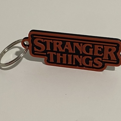 Chaveiro de borracha Stranger Things laranja e preto com argola metálica