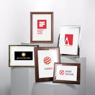 Cinco molduras com certificados de prémios de design exibidas sobre blocos cinza.