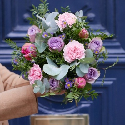 Bouquet colorido com rosas lilás e cravos cor-de-rosa e folhas verdes