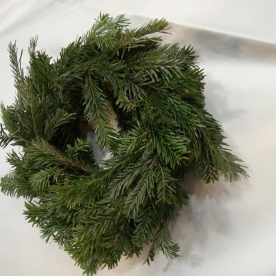 Guirlanda de ramos verdes de pinheiro artificial sobre pano branco