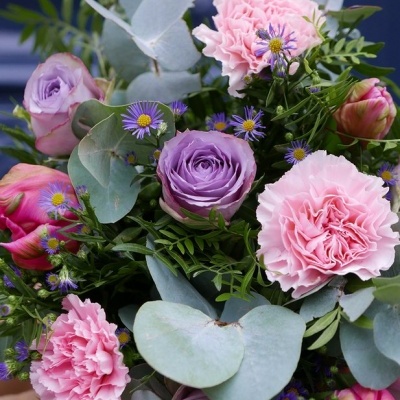 Arranjo floral com flores roxas, cor de rosa e folhas verdes