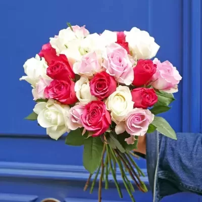 Buquê colorido de rosas com folhas verdes na frente de porta azul e puxador dourado